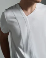 ront view of the white T-shirt displaying the asymmetric crew neck with a distinct strip body detail, meticulously crafted to create a streamlined and modern silhouette.
